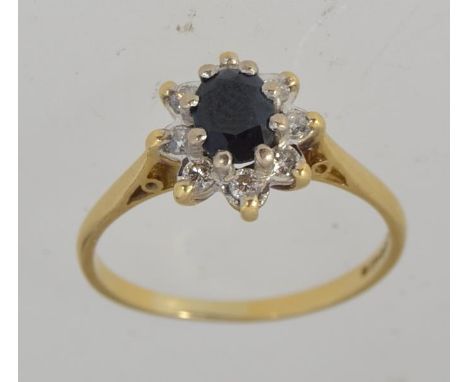 A hallmarked Sheffield 18ct gold sapphire and diamond ladies ring, the diamonds approx 16pnts  surrounding the oval cut sapph