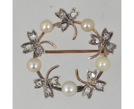 An Edwardian tested 9ct gold wreath brooch pin with clover leaves set with rose cut diamonds interspaced with pearls with rol