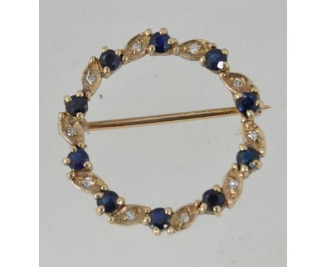 A  vintage 9ct gold hallmarked wreath brooch pin set with sapphires and diamonds with good roller clip clasp. Marked crown 37