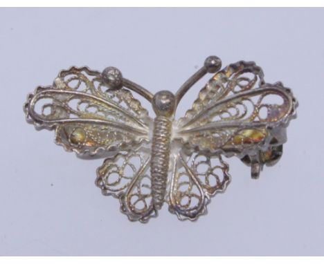 A vintage white metal 900 silver filigree brooch in the form of a butterfly with roller clip clasp. Mark to pin. Measures 2.5