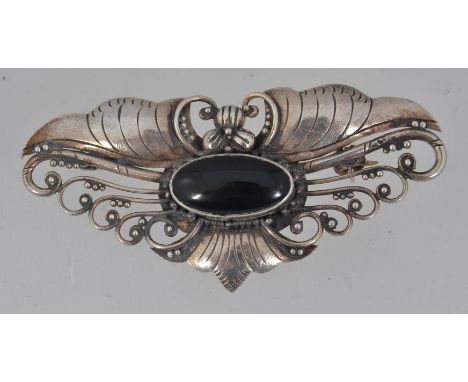 An 800 silver Art Nouveau brooch with onyx set cabouchon and roller clip clasp. Measures 6cms.