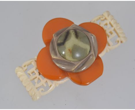 A large 1930s vintage layered bakelite brooch with faux carved ivory Chinese script base with flower and cabochon centre with