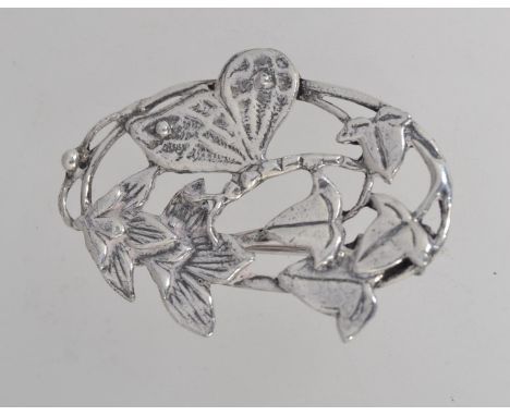 A silver Art Nouveau style brooch with a butterfly feeding from the nectar of a flower with roller clip clasp (tests silver).