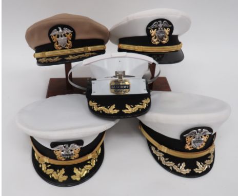 Four US Navy Commander's Capsconsisting light khaki crown and body example.  Black peak with embroidery oak leaves.  Gilt chi