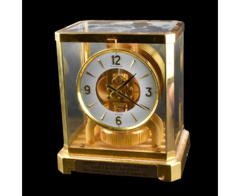 Jaeger LeCoultre Atmos Mantle Clock. Brass case, glass panels. Presentation tag affixed lower. Measures 9-1/4 x 8-1/4" W x 6-