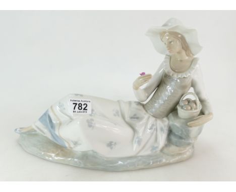 Large Nao figure of a lady reclining on a rock holding a flower, h23cm, L38cm