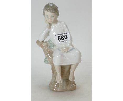 A Lladro figurine of a Boy on a tree trunk