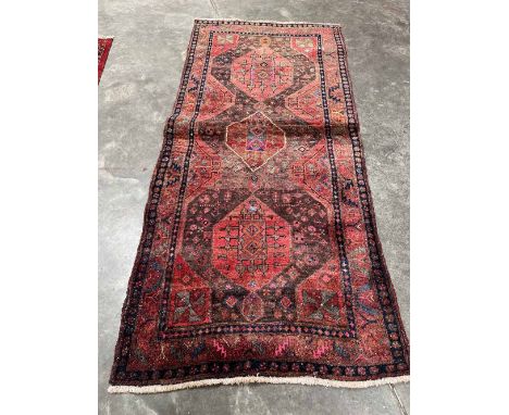 A Persian red ground carpet. 108' x 49'