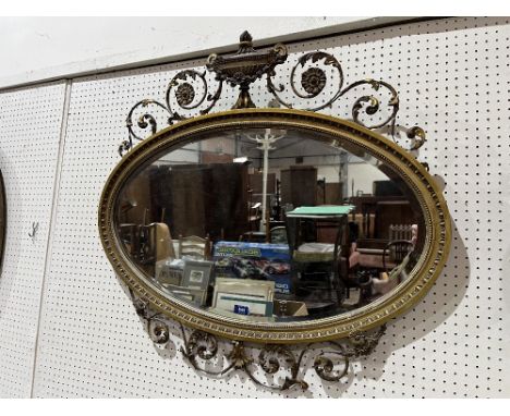 A 19th century Adam revival oval looking glass, with bevelled plate, the frame with wired gesso scrolling foliage and paterae