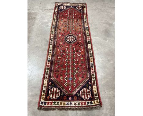 An Afghan red ground carpet runner, 96' x 32'