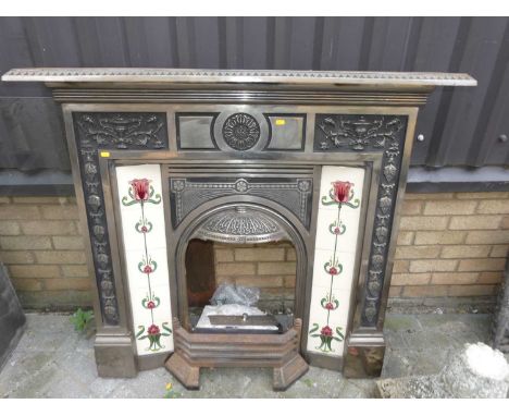 A polished steel and ceramic tiled inset fire surround, in the late Victorian taste, 113 x 125cmCondition is good with some r