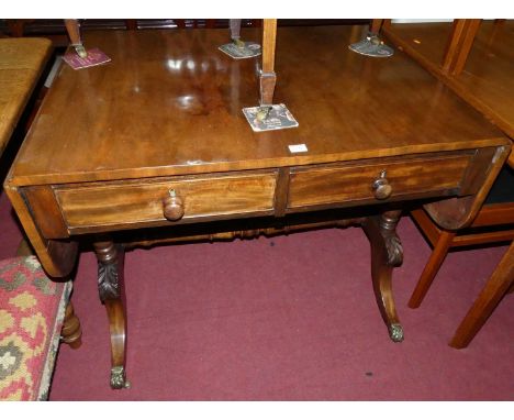 A 19th century mahogany drop-flap sofa table, having twin frieze drawers, raised on acanthus leaf capped swept supports, widt