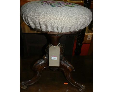 A Victorian floral carved walnut framed and tapestry upholstered circular swivel music stool, height 51cm