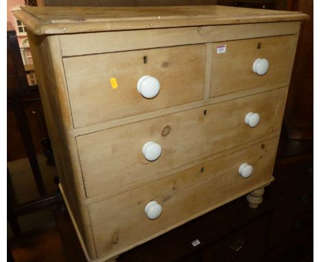 A Victorian pine chest of two short over two long drawers, having white glazed ceramic handles on squat turned supports, widt