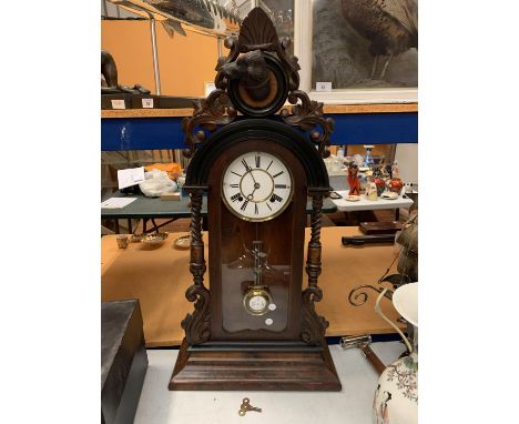 A VERY LARGE ORNATE CARVED MANTEL CLOCK WITH DOG HEAD CAMEO TO TOP - 88CM HIGH (KEY) 