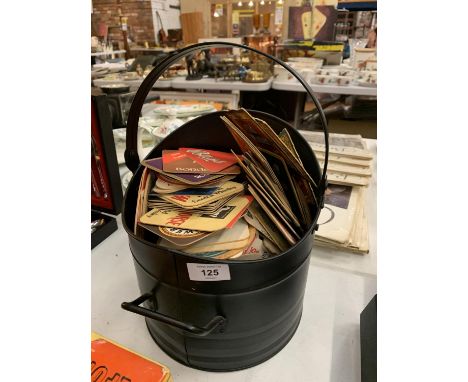 A COAL SCUTTLE CONTAINING A QUANTITY OF VINTAGE BEER MATS 