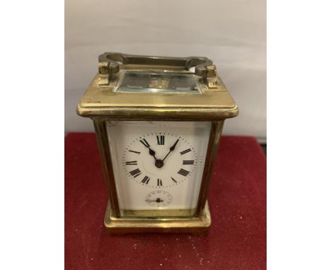 A FRENCH BRASS CARRIAGE CLOCK WITH WHITE ENAMEL DIAL AND SECONDHAND FEATURE (KEY) - 11CM HIGH 