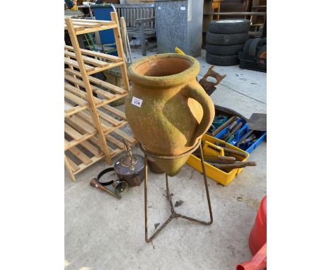A DECORATIVE URN PLANTER WITH WROUGHT IRON STAND 