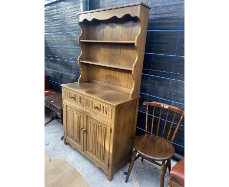 A LIGHT OAK REPRODUCTION DRESSER WITH LINEN FOLD BASE, CUPBOARDS, COMPLETE WITH PLATE RACK, 37.5" WIDE 