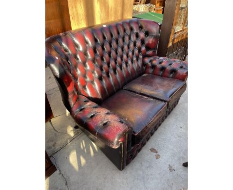 AN OXBLOOD TWO SEATER BUTTON-BACK SETTEE 