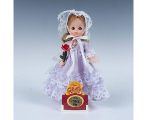 Small adorable figure of a girl wearing a beautiful purple dress while holding a rose. This item has its original box 7"L x 3