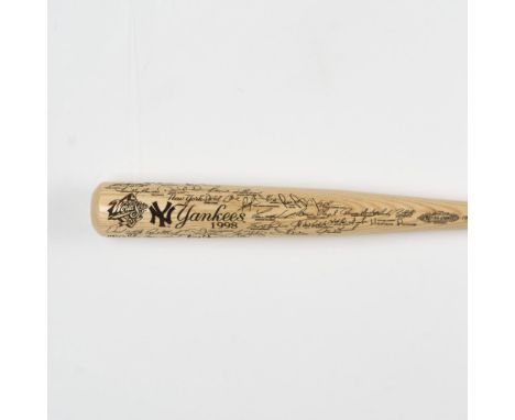 A finely crafted natural wood bat showcasing black-engraved signatures of the 1998 World Series champion New York Yankees. Ma
