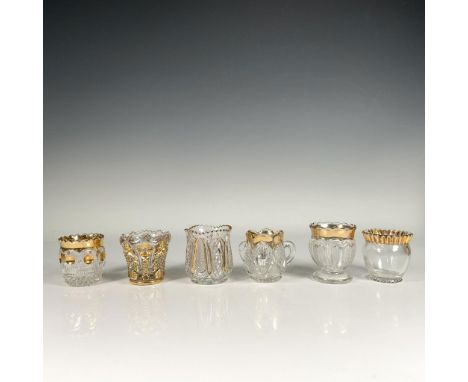 Set of six clear glass holders, featuring flower shaped openings, intricate glass cut designs and gilt accents. Elegant detai