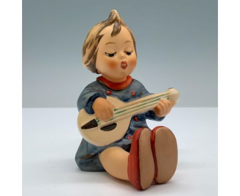 Hand painted porcelain with matte finish features a little boy playing a guitar in his blue doted pajamas. Goebel backstamp. 