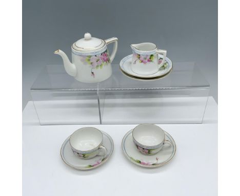 Magnificent collection of floral decorated drinkware that includes a creamer jug, a tea pitcher, two tea cups with two saucer