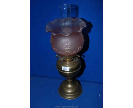A Brass Oil Lamp with pink glass shade