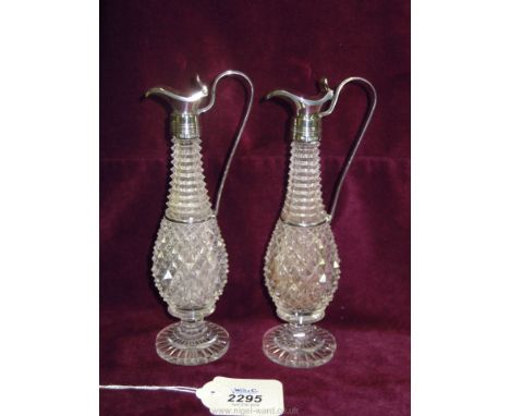 A pair of cut glass oil Decanters of slender baluster shape, the necks with octagonal deep ring cuts, the body with sharp dia