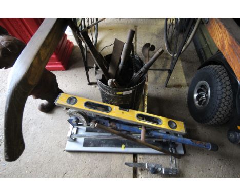 A metal bucket and contents of various hand tools together with a JCB spirit level, pipe bender etc.