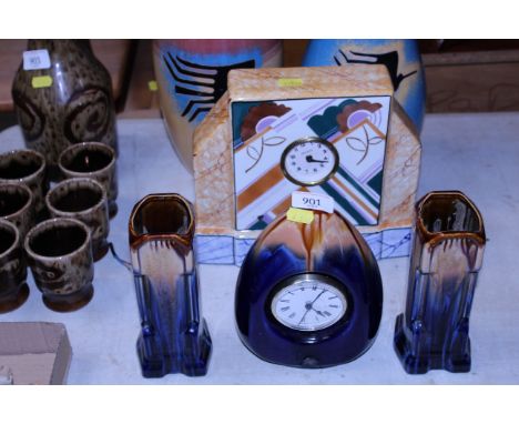 An Art Deco style pottery clock and garnitures together with another Art Deco style clock 