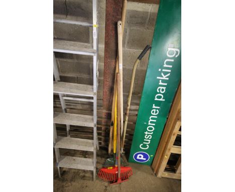 A quantity of long handled garden tools to include a Wolf Tools rake, garden hoes, long handled brush etc.