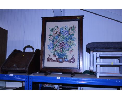 An embroidered oak framed fire screen