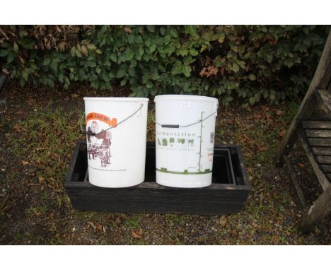 Two plastic fermentation buckets and a wooden plant trough