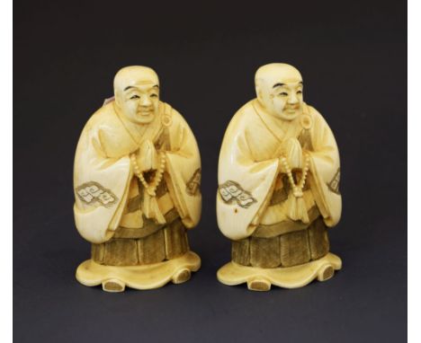 Pair of early 20th Century Japanese carved ivory okimono of monks, late Meiji/Taisho, each figure with bald head, wearing a c