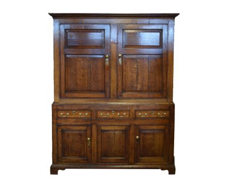 George III oak and mahogany press cupboard, the upper stage having a moulded cornice over a pair of fielded panelled doors wi