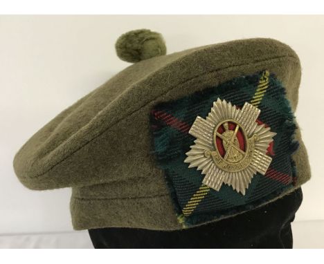 A Royal Scots green felt Tam "O" Shanter complete with cap badge on a hunting Stuart tartan patch.  