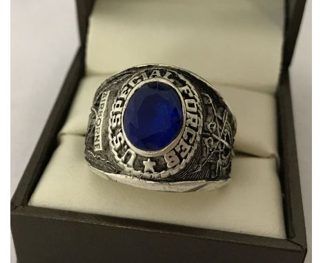 A Vietnam War style US Special Forces ring set with central blue stone.   UK size W, US size 11½.