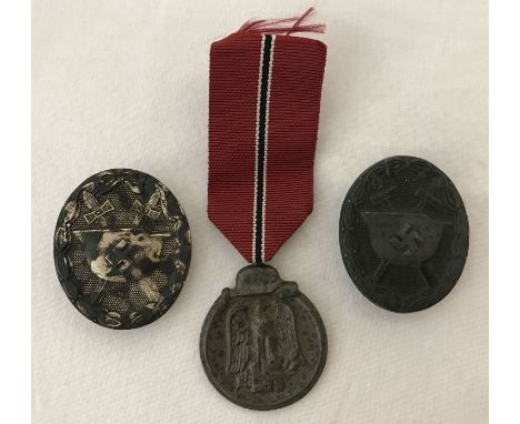 A WWII style German Eastern Front medal and ribbon, together with 2 pin back wound badges.  