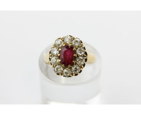 A ruby and diamond cluster ring, the oval cut stone multi claw set in a border of ten old cut diamonds