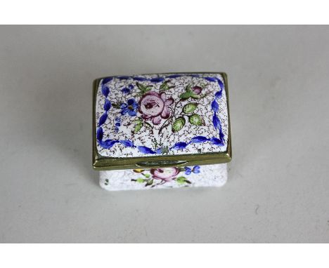 An 18th century enamel patch box with floral design on white ground, opening to reveal a mirror, 3.5cm