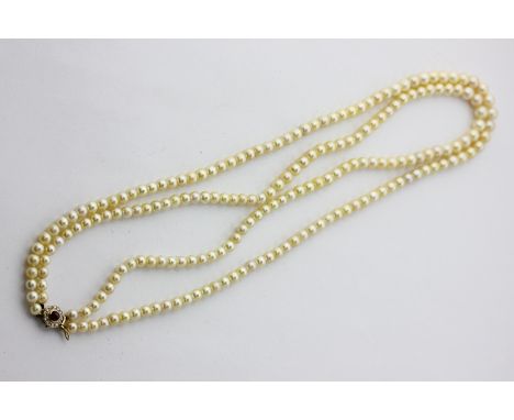 A two row cultured pearl necklace on a cabochon ruby and diamond clasp