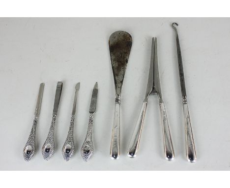 An Edward VII silver handled four piece manicure set of various tools, a George V silver handled button book and shoe horn, a