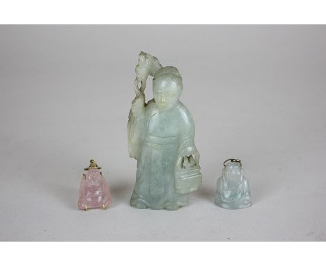 A Chinese carved green jade type stone figure holding a staff and basket, 10cm high, together with a small rose quartz Buddha