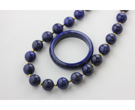 A lapis lazuli bead necklace, the large beads strung on a gilt metal clasp, and a lapis lazuli bangle