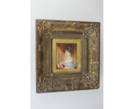 A 19th century portrait miniature of a lady seated beside a window, her black hair in ringlets, wearing a lace gown trimmed w