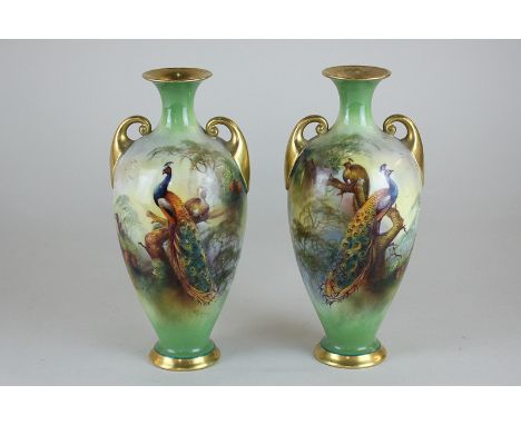 A near pair of Royal Worcester porcelain two-handled vases decorated with peacock and peahen amongst woodland, both signed FJ