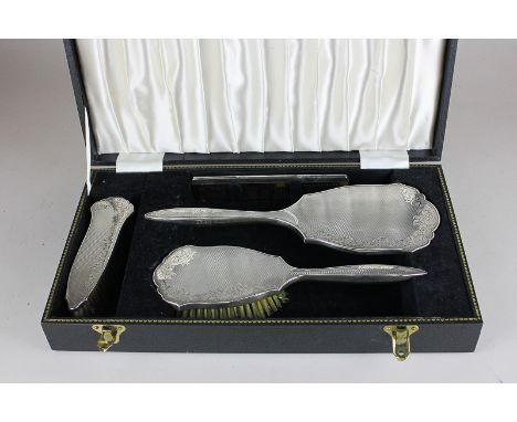 An Elizabeth II silver backed dressing table set of hand mirror, hair brush, clothes brush and comb, in fitted case with flor